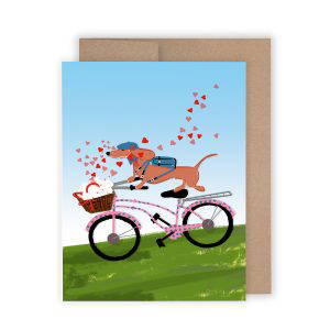 Gilmore and Friends drawing of a red dachshund on a pink bike with blue polkadots delivering a basket filled with love letters